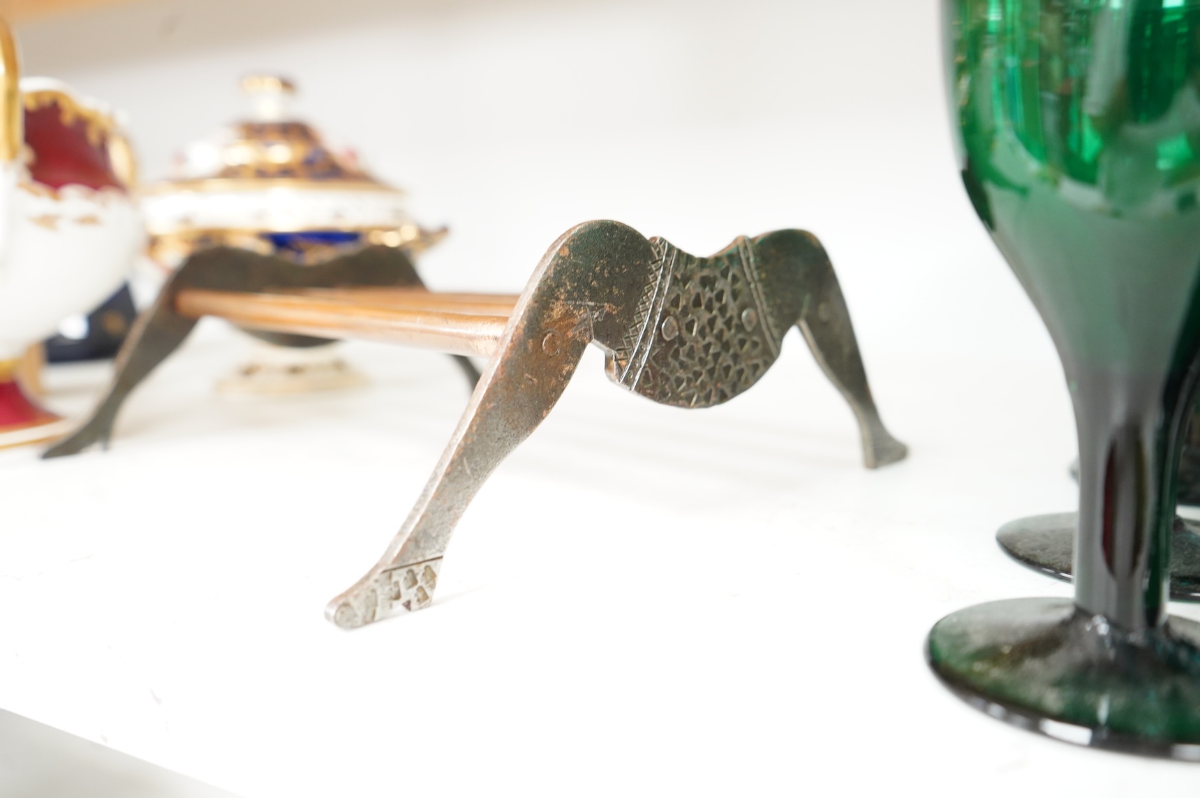 An engraved iron and copper novelty lady's legs stand, 21cm wide